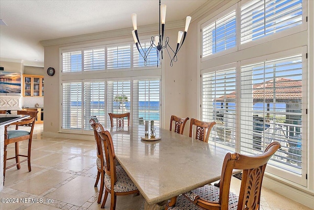 dining area with crown molding, a high ceiling, and a notable chandelier