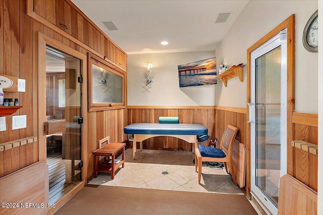 dining space featuring wood walls and light tile patterned flooring