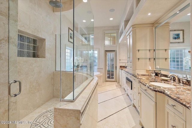 bathroom with independent shower and bath, vanity, and tile patterned floors