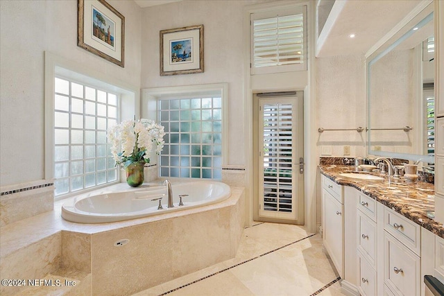 bathroom featuring tiled bath and vanity