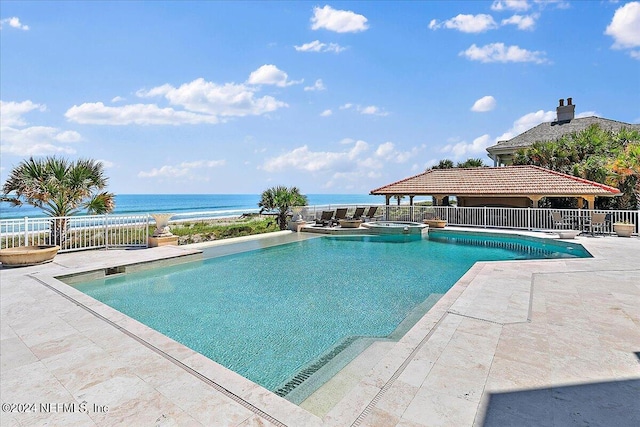 view of swimming pool featuring a water view and a patio area