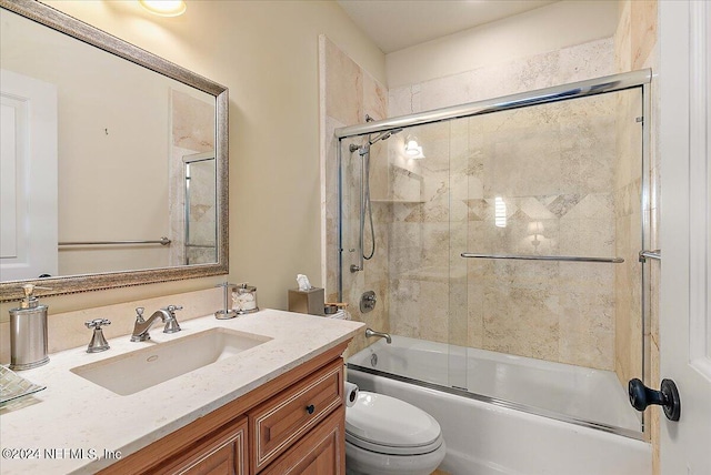 full bathroom with enclosed tub / shower combo, vanity, and toilet