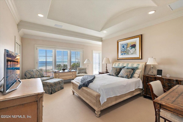 bedroom featuring carpet, ornamental molding, and a tray ceiling