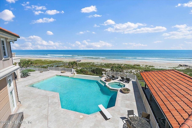 view of swimming pool with a water view, a beach view, and a patio area