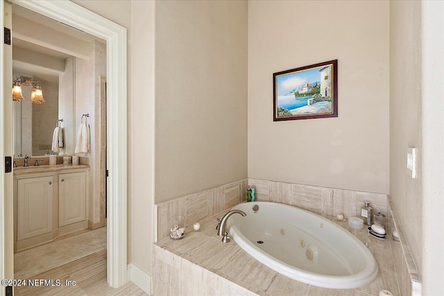 bathroom featuring vanity and tiled bath