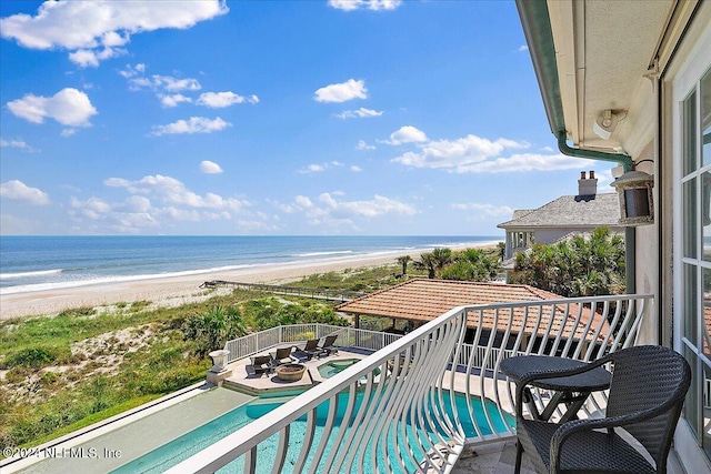 balcony featuring a beach view and a water view