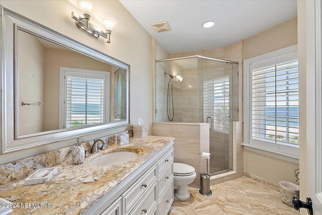 bathroom with vanity, toilet, and a shower with shower door