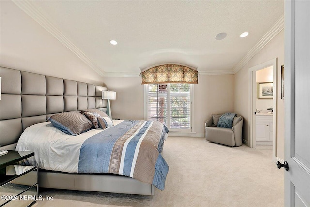 carpeted bedroom with a textured ceiling, lofted ceiling, ornamental molding, and ensuite bath