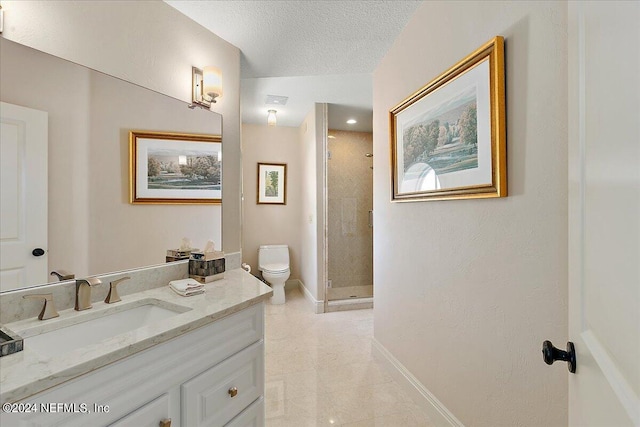 bathroom with vanity, a textured ceiling, a tile shower, tile patterned flooring, and toilet