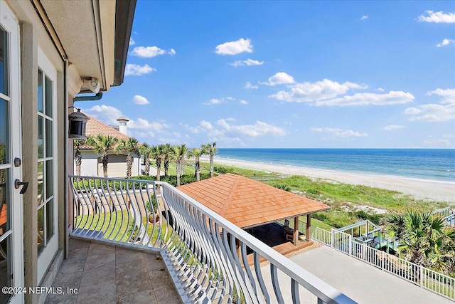 balcony featuring a beach view and a water view