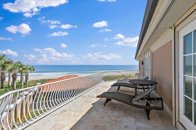 balcony with a water view and a beach view