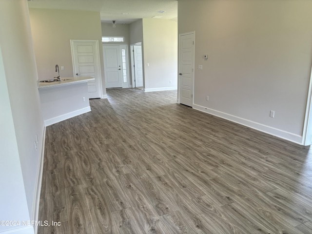 unfurnished living room with dark wood-type flooring and sink