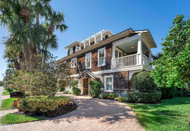 view of front of house featuring a front lawn and a balcony