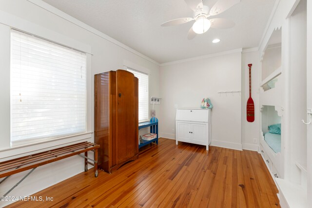 interior space with ornamental molding, ceiling fan, and light wood-type flooring