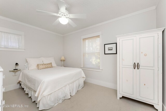 bedroom with ceiling fan, light carpet, and ornamental molding