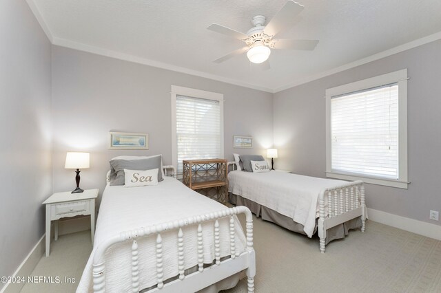 carpeted bedroom featuring ceiling fan and crown molding