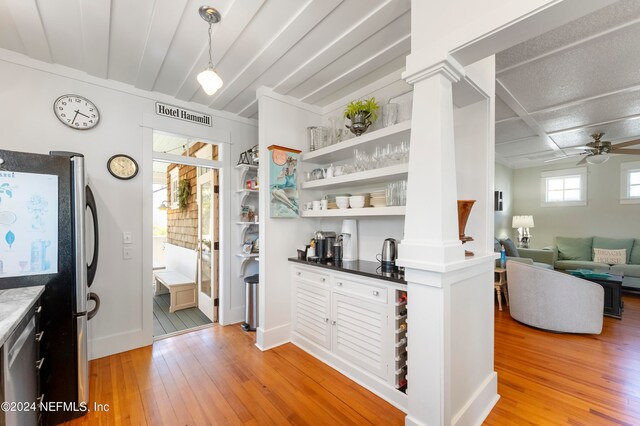 kitchen featuring decorative light fixtures, stainless steel appliances, ceiling fan, decorative columns, and light wood-type flooring