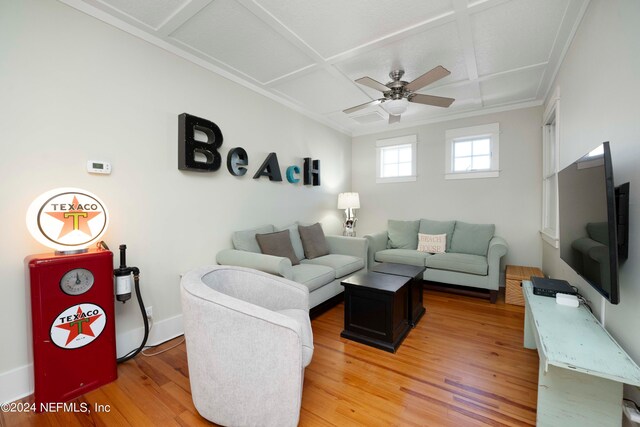 living room with ornamental molding, ceiling fan, light wood-type flooring, and coffered ceiling