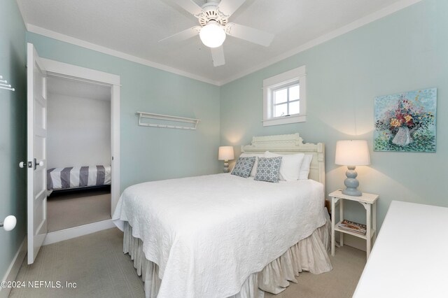 bedroom featuring light colored carpet, ceiling fan, and crown molding