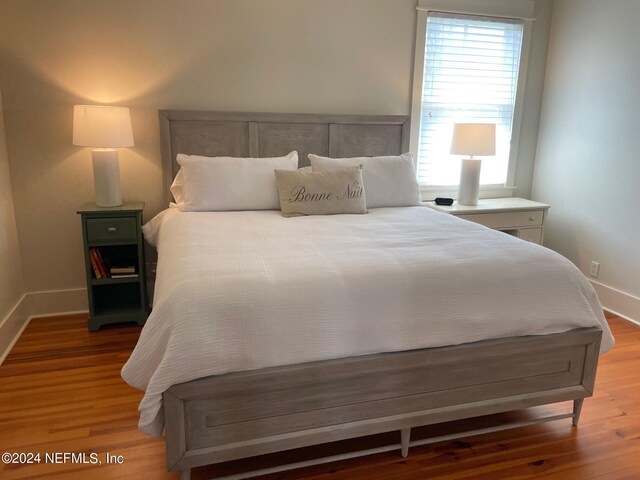 bedroom featuring hardwood / wood-style flooring and multiple windows