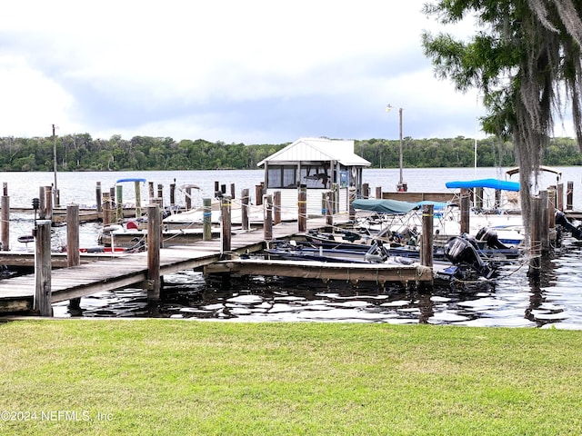 view of dock with a water view and a yard