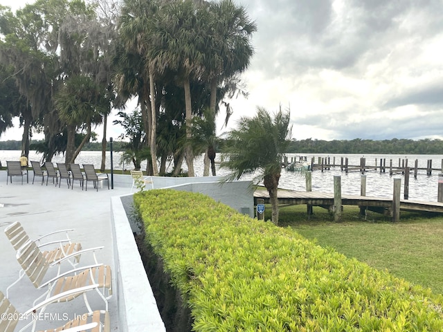 dock area with a water view and a lawn