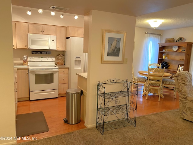 kitchen with white appliances, light brown cabinetry, and light wood-type flooring