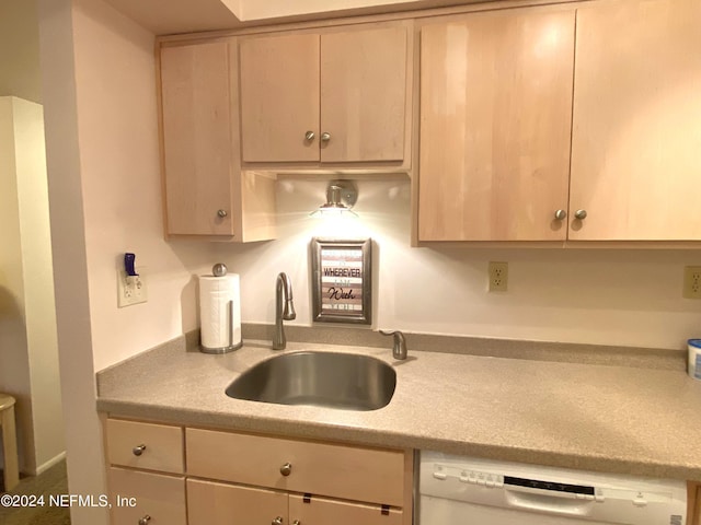 kitchen with light brown cabinetry, sink, and dishwasher