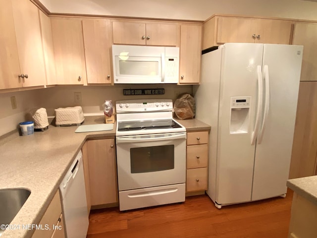 kitchen with light brown cabinets, white appliances, and wood-type flooring