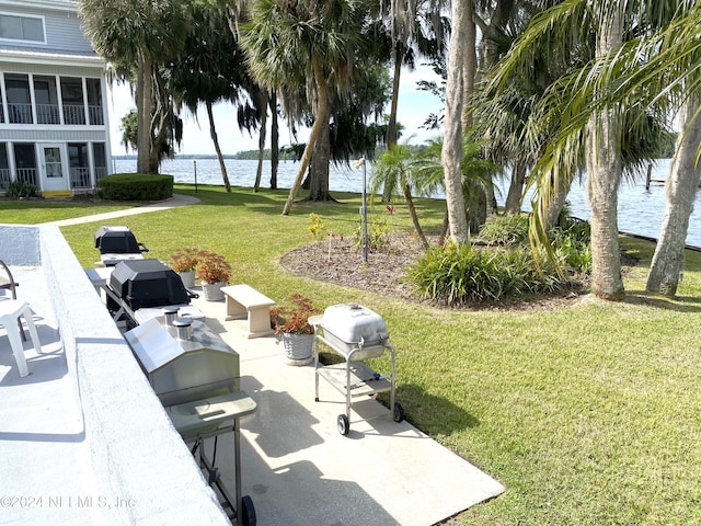 exterior space featuring a water view, a lawn, and a patio area