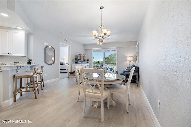 dining room featuring light hardwood / wood-style flooring and an inviting chandelier