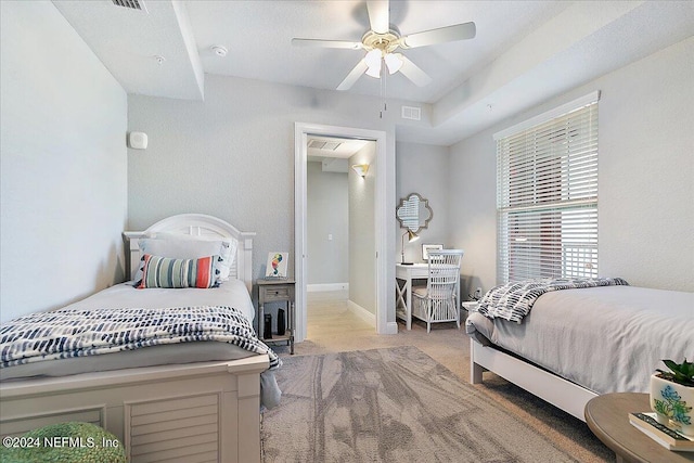 carpeted bedroom featuring a ceiling fan, visible vents, and baseboards