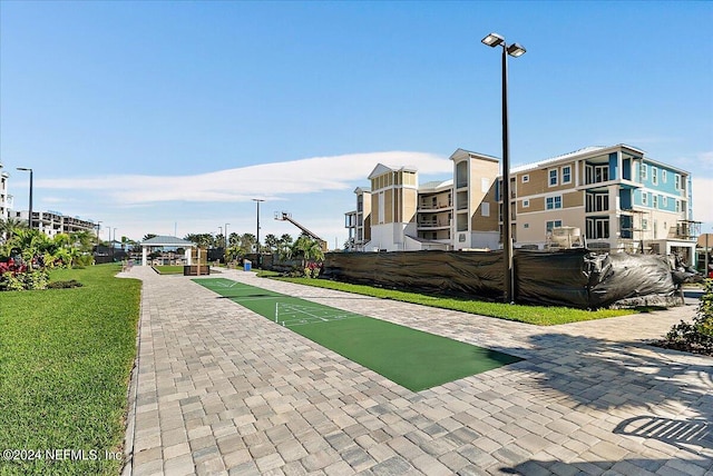 surrounding community with shuffleboard and a yard