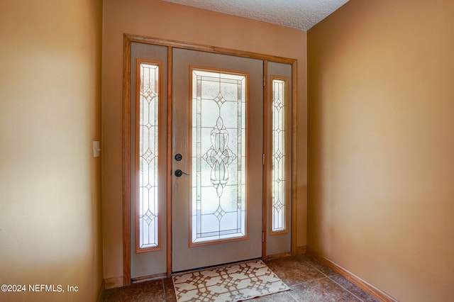 entrance foyer featuring light tile floors and a textured ceiling