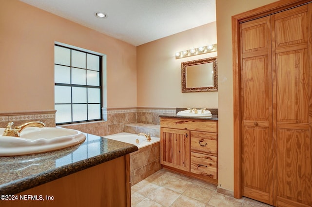 bathroom featuring tiled bath, tile floors, and vanity