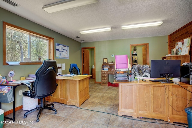 tiled office space with a textured ceiling