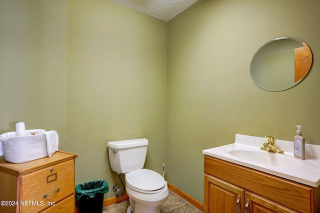 bathroom featuring toilet, tile flooring, a textured ceiling, and vanity