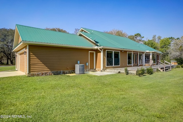 back of house featuring central AC unit, covered porch, and a lawn