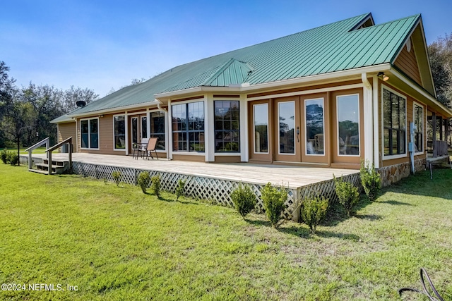 rear view of property with a lawn and a deck