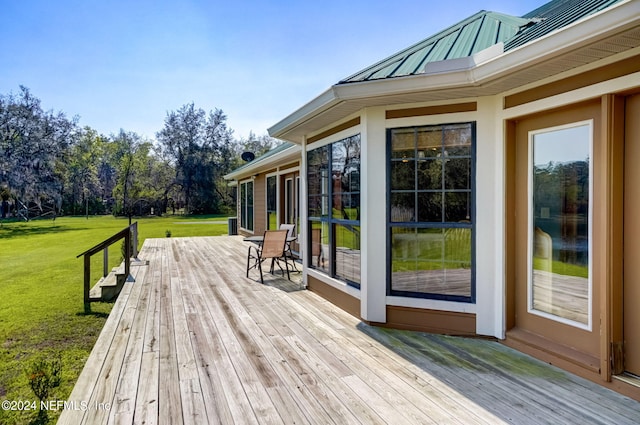 deck with a sunroom and a yard