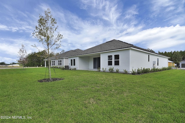 rear view of property with a lawn