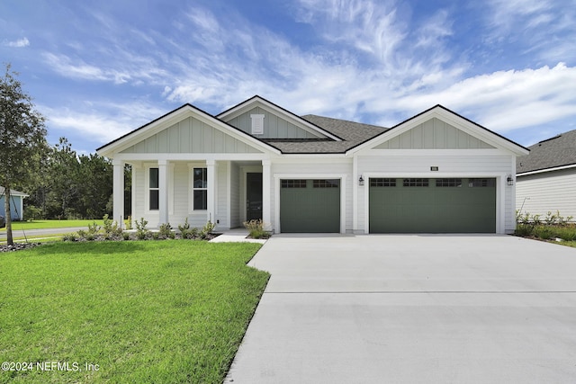 view of front facade with a front lawn, covered porch, and a garage