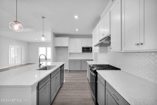 kitchen featuring sink, hanging light fixtures, light stone counters, white cabinetry, and stainless steel appliances