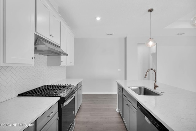 kitchen with pendant lighting, sink, white cabinets, and stainless steel appliances