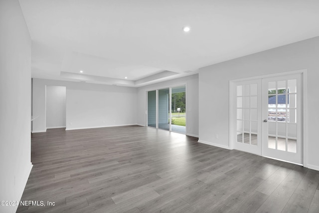 unfurnished room with a tray ceiling, hardwood / wood-style floors, and french doors