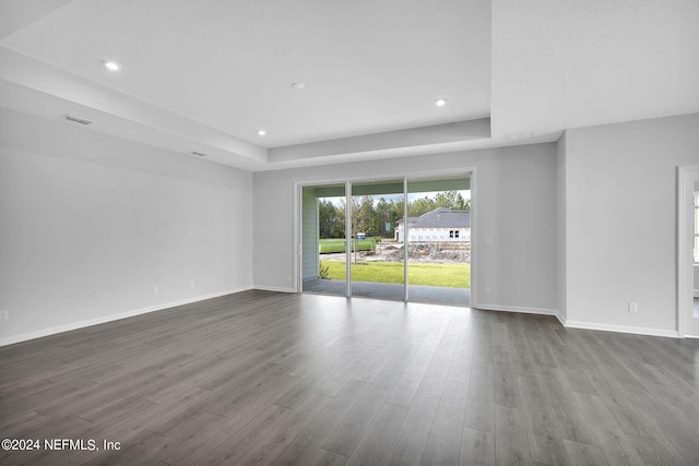 unfurnished room featuring wood-type flooring and a raised ceiling