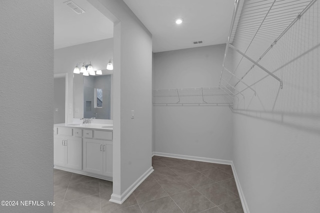 spacious closet with light tile patterned floors and sink