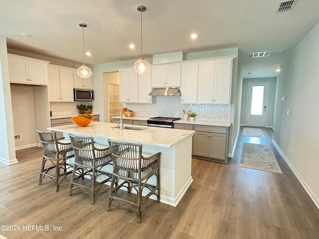 kitchen featuring white cabinets, an island with sink, stainless steel appliances, and sink