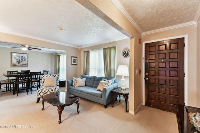 living room with light carpet, a textured ceiling, ceiling fan, and crown molding