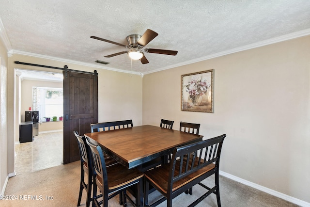 carpeted dining space with ceiling fan, a barn door, crown molding, and a textured ceiling